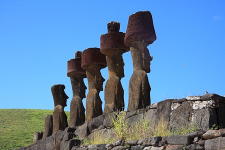 Rij moai bij strand Anakena, enkele met zgn. pukao (rode hoed), Paaseiland, Chili.