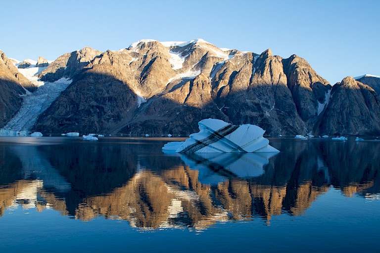 Spiegeling van ijsberg en bergketen in de Nordvestfjord.
