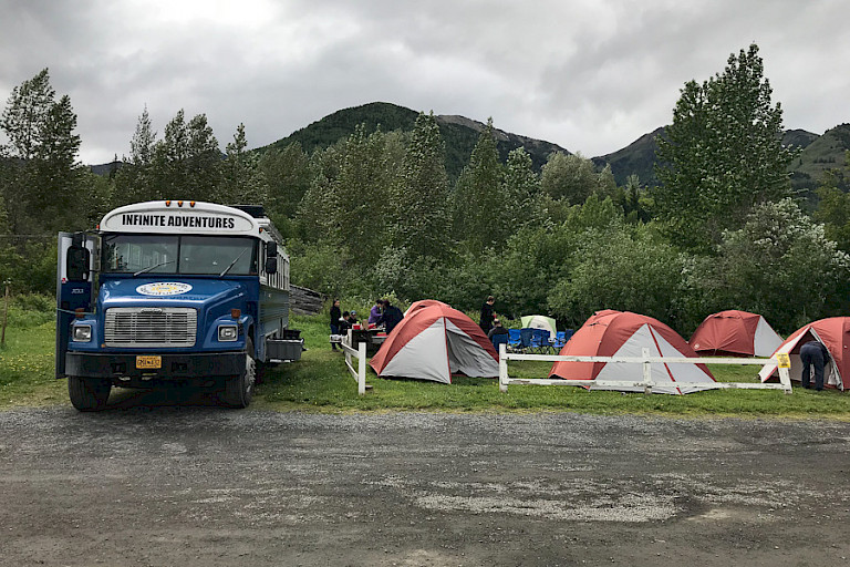 De bus en tenten op de camping.