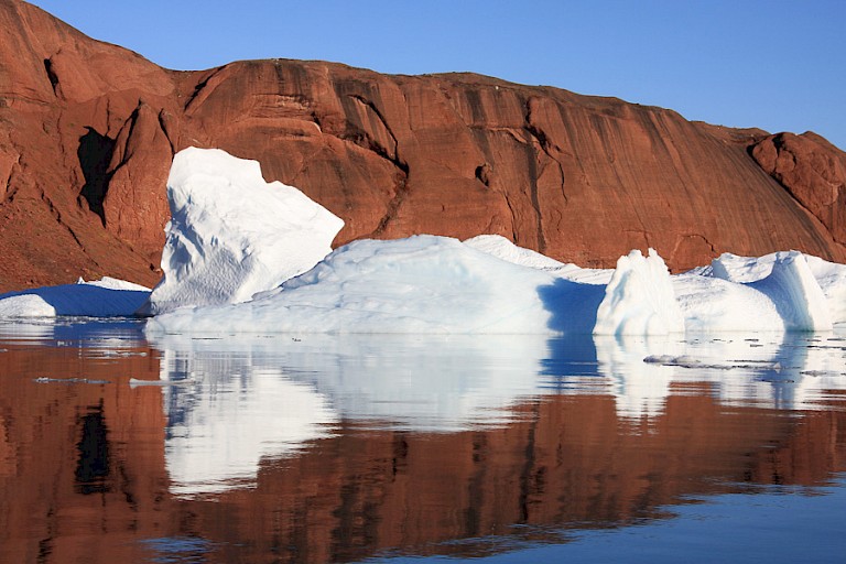 Een mooi contract van de blauwwitte ijsbergen tegen het rode gebergte bij het eiland Røde.