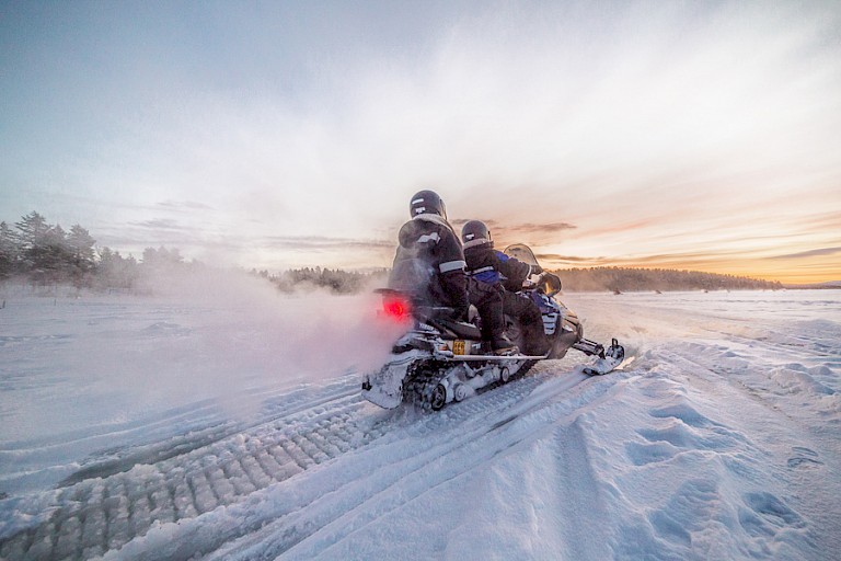 Door een sneeuwbarrière met de sneeuwscooter.