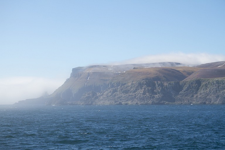Langzaam doemt de steile kust op.