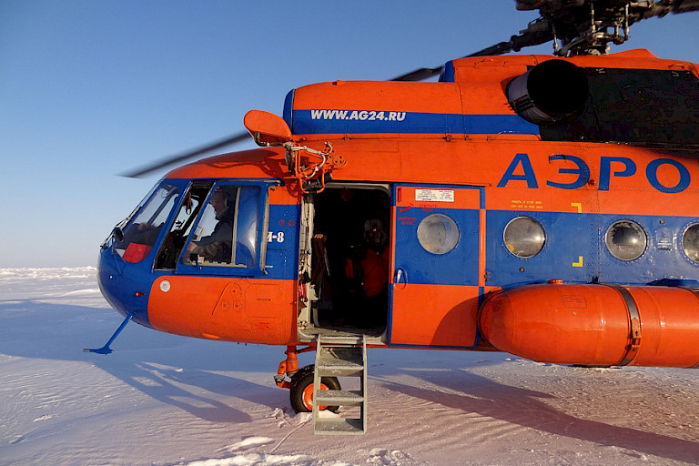 De helikopter brengt de deelnemers van de ijsbasis Barneo naar 89°NB.