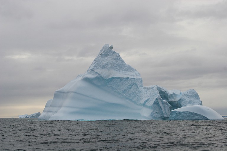 Immense ijsbergen drijven voor de kust langs.