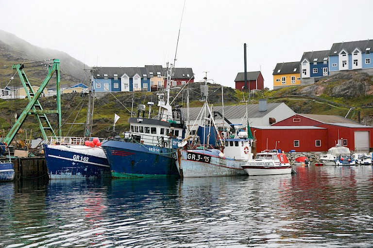 Het haventje van Narsaq met kleurrijke huizen op de achtergrond.