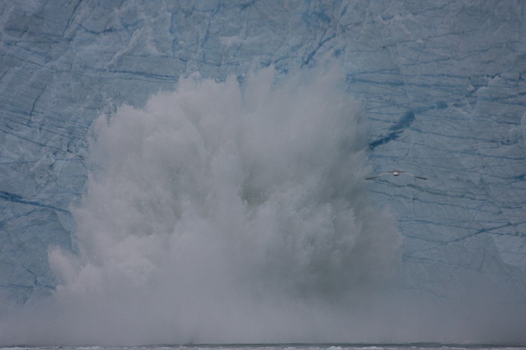 Een afgekalfd stuk ijs veroorzaakt een enorme plons en daarna vloedgolf.