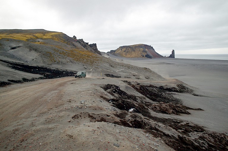 Het desolate landschap van Jan Mayen met de Brielsche Toren op de achtergrond.